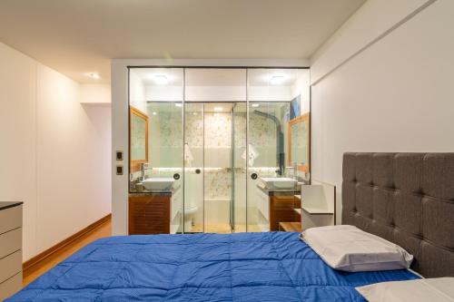 a bedroom with a bed and a bathroom with a shower at Corpac Apartment in Lima