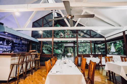una sala da pranzo con tavoli e sedie bianchi di Daintree Wilderness Lodge a Daintree