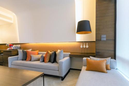 a living room with two couches and a table at Le Meridien Bangkok in Bangkok