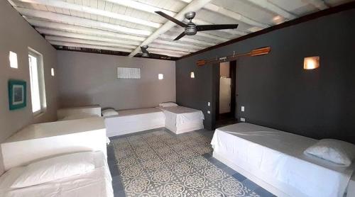 Habitación con 3 camas y ventilador de techo. en KokohauBungalows en Santa Veronica