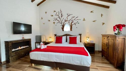 a bedroom with a bed with red pillows and a fireplace at Hotel Boutique & Spa - VDL Colonial in Villa de Leyva