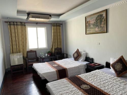 a hotel room with two beds and a window at Mekong Hotel in Ban Nabông