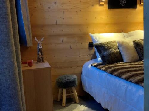 een slaapkamer met een bed en een houten muur bij Appartement Val Thorens, 3 pièces, 4 personnes - FR-1-637-44 in Val Thorens