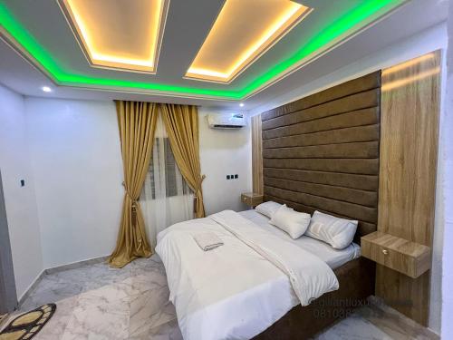 una camera da letto con un grande letto con illuminazione verde di Gillant Luxury Homes a Benin City