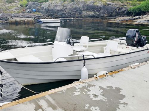 a white boat parked at a dock in the water at 6 person holiday home in Onarheim in Onarheim