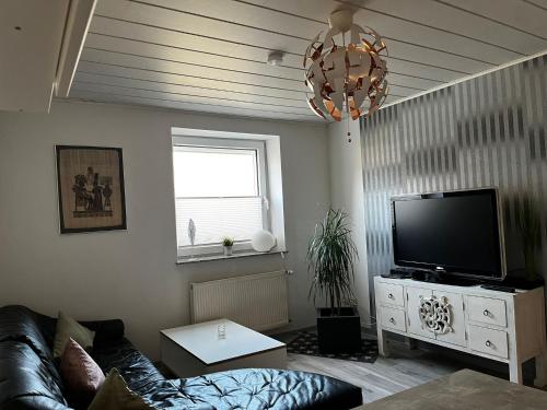 ein Wohnzimmer mit einem Sofa und einem Flachbild-TV in der Unterkunft Timeout Westerwald in Ellar