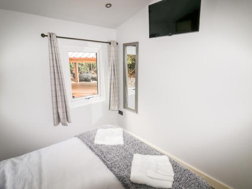 a bedroom with a bed and a tv on the wall at Celyn in Ruthin