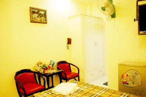 a room with two chairs and a table and a bed at Lan Anh Hotel in Ho Chi Minh City