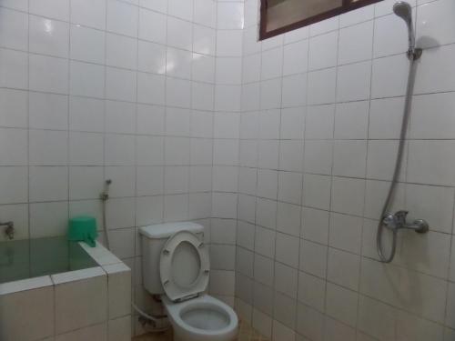 a bathroom with a toilet and a shower in it at Sukapura Permai Hotel in Lambangkuning