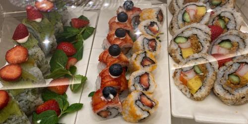 a group of sushi dishes on trays with fruit at Monarch Plaza Hotel in Taoyuan