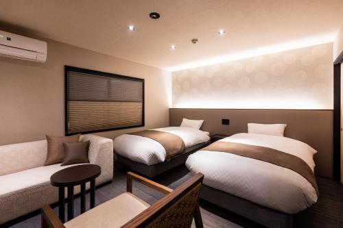 a room with two beds and a couch and a room with two beds at Rinn Kiyomizu Gojo Machiya in Kyoto