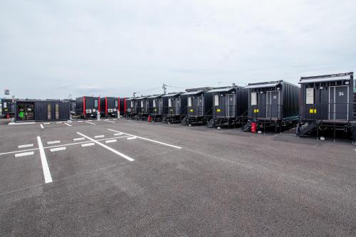 a parking lot with rows of containers in a lot at HOTEL R9 The Yard Uki in Uki