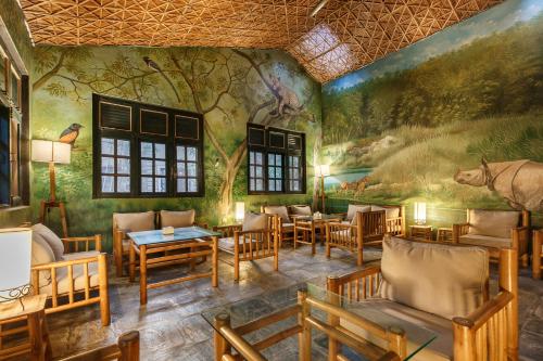a restaurant with a mural on the wall at Green Mansions Jungle Resort in Sauraha