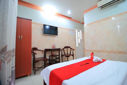 a bedroom with a bed with a red blanket at RedDoorz Chin Sao Hotel Nguyen Thi Thap in Ho Chi Minh City
