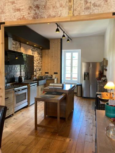 a large kitchen with a table in the middle of it at Maison Graciateguy in Saint-Étienne-de-Baïgorry