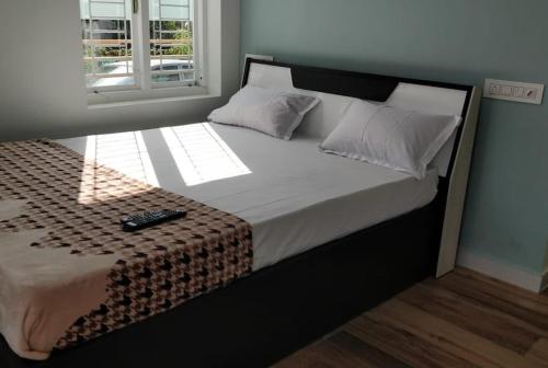 a bedroom with a bed with a remote control on it at AB ISLAND RESIDENCY in Munroe Island