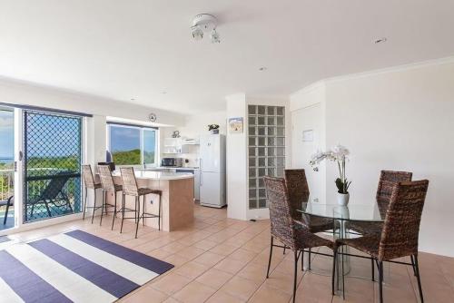 a kitchen and dining room with a glass table and chairs at 12 60 Peregian Esplanade Peregian Beach in Peregian Beach