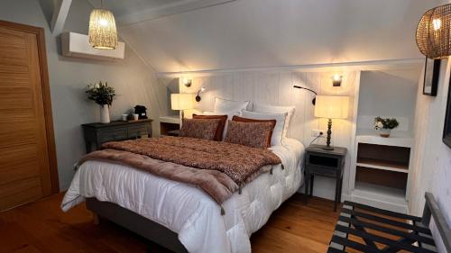 a bedroom with a large bed and two lamps at La Plonploniere in Aix-en-Issart
