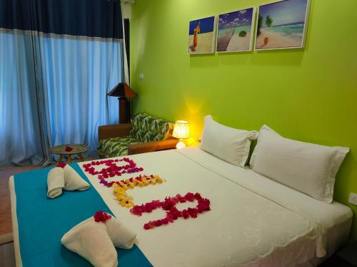 ein Hotelzimmer mit einem Bett mit Blumen darauf in der Unterkunft Nadi Fancy Hotel in Nadi