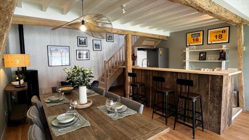 a kitchen and dining room with a table and a bar at La Plonploniere in Aix-en-Issart
