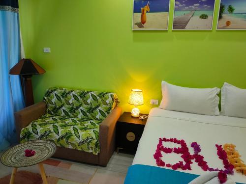 a bedroom with a bed and a couch and a chair at Nadi Fancy Hotel in Nadi