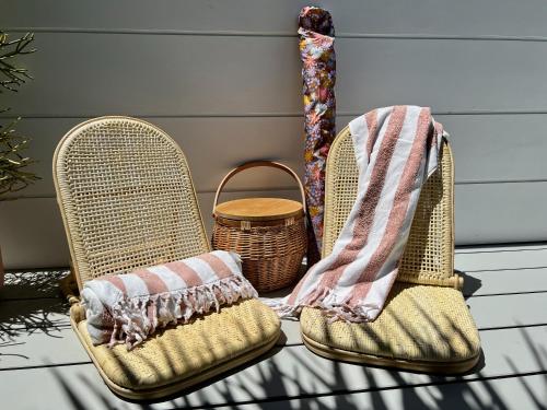 2 chaises en osier avec des couvertures et un panier dans l'établissement Scandi Beach apartment, à Avalon