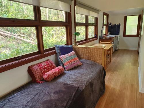 a bedroom with a bed with pillows on it at Heaven in the Hills Retreat in Maleny