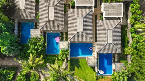 an aerial view of a house with blue swimming pools at Wanda Reign Resort & Villas Sanya Haitang Bay in Sanya