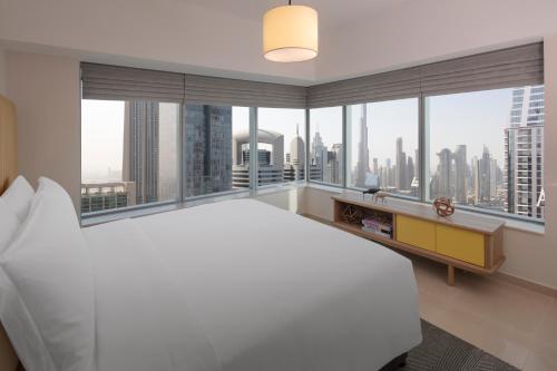 a bedroom with a large white bed and large windows at Staybridge Suites Dubai Financial Centre, an IHG Hotel in Dubai