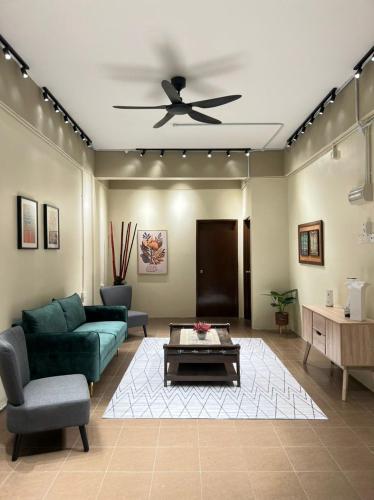 a living room with a couch and a ceiling fan at Pillow Home Town City in Kuala Terengganu