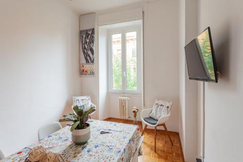 uma sala de jantar com uma mesa e uma televisão em Il Melograno Holiday House em Roma