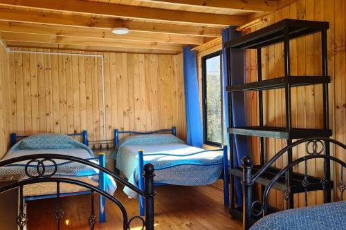 1 dormitorio con 2 camas en una habitación con paredes de madera en EL GRAN ROBLE. en Constitución