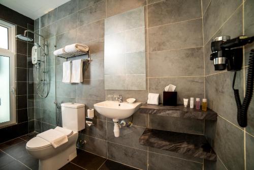 a bathroom with a white toilet and a sink at The Signature Serviced Suites Puchong in Puchong