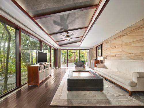 a living room with a couch and a tv at Wanda Reign Resort & Villas Sanya Haitang Bay in Sanya