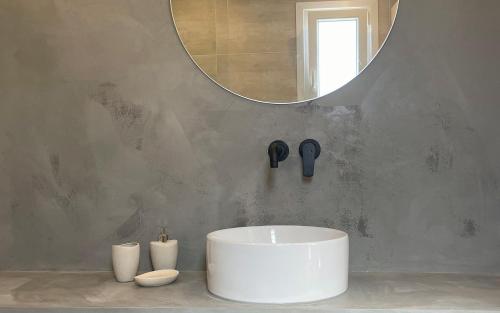 a bathroom with a white sink and a mirror at Olvion Suites in Skala Sotiros
