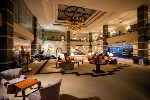 un grand hall avec des canapés, des chaises et un lustre dans l'établissement Otaru Asari Classe Hotel, à Otaru