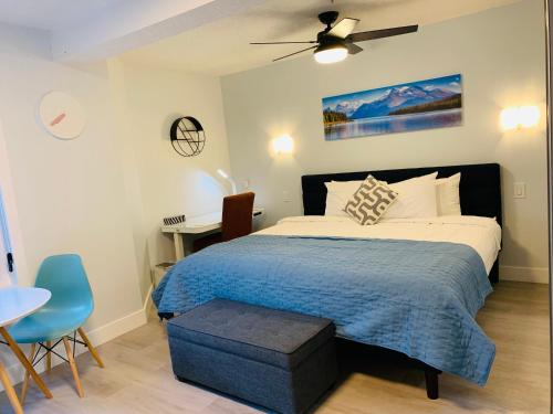 een slaapkamer met een bed met een blauwe deken en een tafel bij A Romantic Studio with Full Kitchen & AC-141 in Canmore