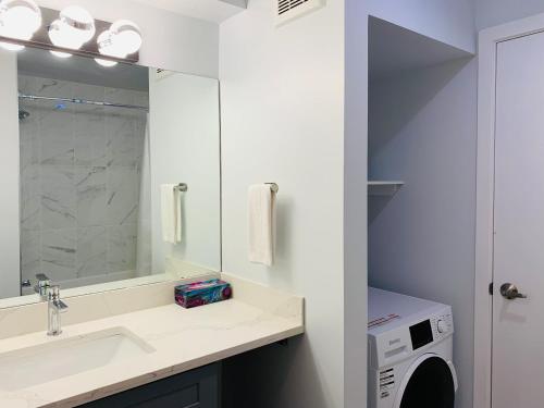 een badkamer met een wastafel en een wasmachine bij A Romantic Studio with Full Kitchen & AC-141 in Canmore