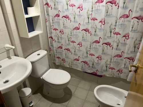 a bathroom with a toilet and a pink flamingos shower curtain at Apartamento a pie de pistas de Espot ZZ House in Espot