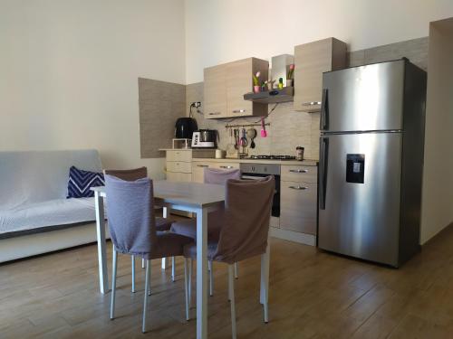 a kitchen with a table and a stainless steel refrigerator at La culla di Giove in Terracina