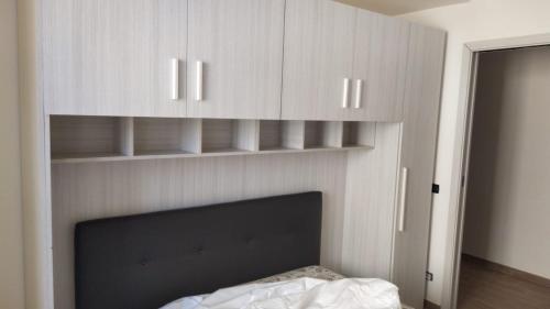 a bedroom with white cabinets and a bed in it at La culla di Giove in Terracina