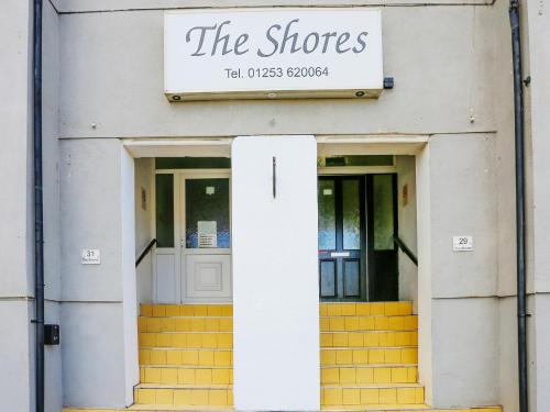 a store with two doors and a sign that reads the shops at OYO The Shores Hotel, Central Blackpool in Blackpool