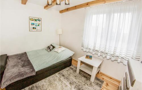 a small bedroom with a bed and a table at Beautiful Home In Ruciane-nida With 4 Bedrooms And Outdoor Swimming Pool in Karwica