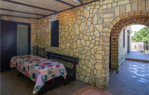 a room with a stone wall with a bed in it at Gorgeous Apartment In Njivice With Kitchen in Njivice