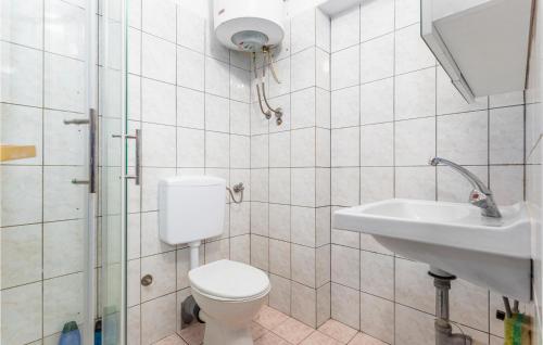 a white bathroom with a toilet and a sink at Gorgeous Apartment In Njivice With Kitchen in Njivice