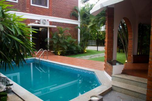 a swimming pool in front of a house at BRICK CASTLE in Chennai