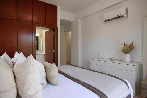 a bedroom with a bed with white sheets and pillows at Phaedrus Living: City View Luxury Flat Androcleous in Paphos City