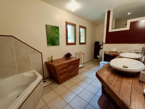 a bathroom with a tub and a sink and a toilet at Villa de la croix de la main in Veyrignac