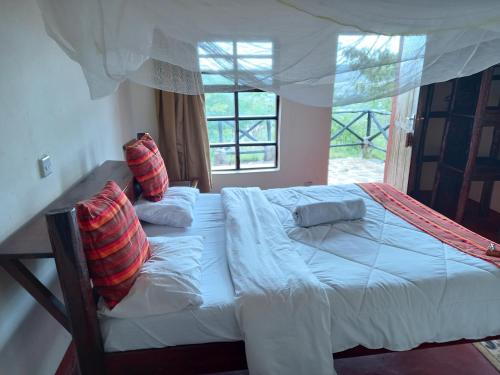 a bedroom with a large bed with a window at Ngari Hill EcoLodge, Maralal - Kenya in Maralal