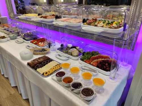 un buffet avec de nombreux types de nourriture sur une table dans l'établissement Biały Dom Henlex Hotel Restauracja, à Poznań